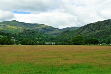 Obraz premium Mountain landscape with green grass and clouds, in Coniston, in the Lake District, Cumbria, England,