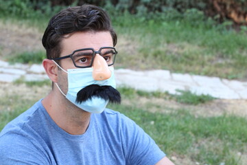 Man wearing fake nose, eyeglasses, mustache and PPE 