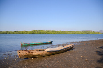 Naklejka na ściany i meble View of the Estuary Padre Ramos Natural Reserve in Nicaragua, its inhabitants are mainly fisherman. Old traditional fishing boats in the shore of the mangrove. water. 