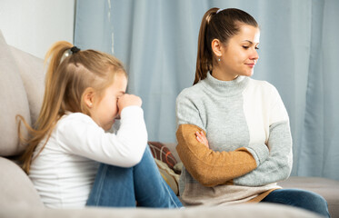 Unhappy young woman having communication conflict with small daughter crying