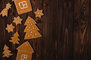Christmas gingerbread cookies in shape of trees6 houses and stars on a wooden table. Top view,...