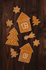 Christmas gingerbread cookies in shape of trees6 houses and stars on a wooden table. Top view, flat lay.