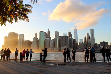 People enjoying the sunset at the Dumbo Pier, Brooklyn, facing the skyline of Manhattan 