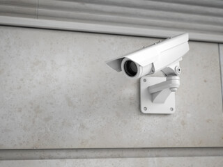 Modern white CCTV camera on a wall. Security monitoring concept. 3d rendering