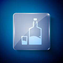 White Tequila bottle and shot glass icon isolated on blue background. Mexican alcohol drink. Square glass panels. Vector.
