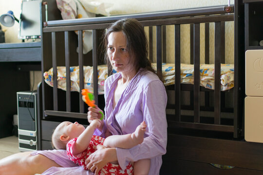 Tired Mother With Baby Indoors.