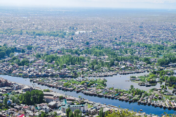 View of lush green city on river bank.