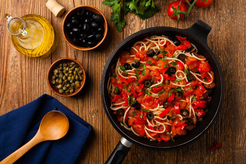 Italian spaghetti alla Pultanesca with tomatoes and olives. Served without meat and cheese.