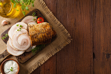 Whole bacon roulade. Served in sliced meat with white sauce. Top view.