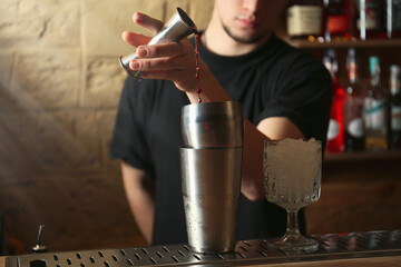 Bartender preparing fresh alcoholic cocktail at bar counter, closeup