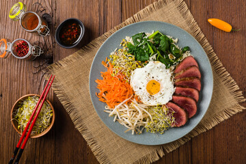 Korean beef with sprouts, spinach and fried egg.