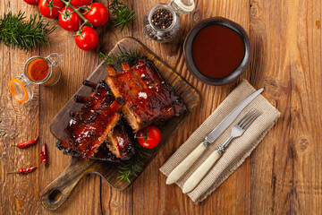 Roasted pork ribs in a bbq sauce. Served on a wooden board. Top view.
