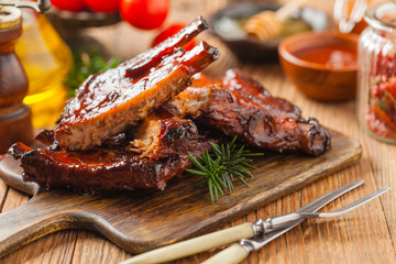 Roasted pork ribs in a bbq sauce. Served on a wooden board. Front view.
