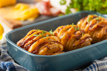 Baked potatoes in Swedish. Hasselback. Stuffed with cheese and bacon. Top view.