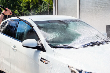 water jet from a hose on the windshield at a self-service car wash