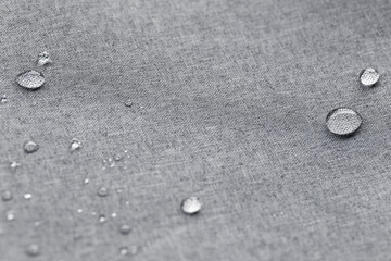 Waterproof droplets on fabric. Grey Canvas Polyester texture synthetical for background. Black polyester textile backdrop for interior art design or add text message.