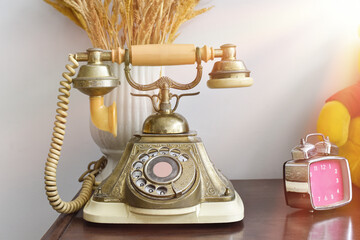 Vintage telephone on wood table background. Rotary antique phone.