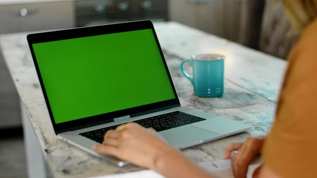 unrecognizable woman using laptop for video call Rbbro. greeting, waving female indoors. chroma key green screen. concept copy space, mock up. conversation with friend