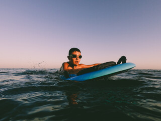 A young boy learning in body board outdoors in the shoreline in a sunny day of summer