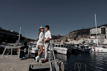 lifestyle engagement photo session young man and woman near yachts, couple in the city