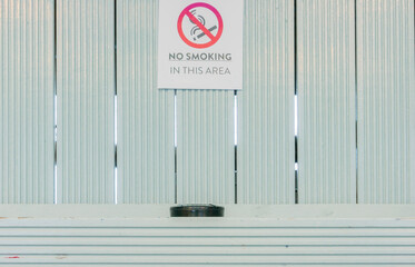 Iconic no smoking in this area sign with a contradictory ashtray beneath that warning 