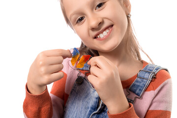 Little girl with orthodontics appliance isolated on white background.