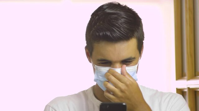 Dark-haired black-haired boy wearing a mask taking selfies and uploading them to the internet