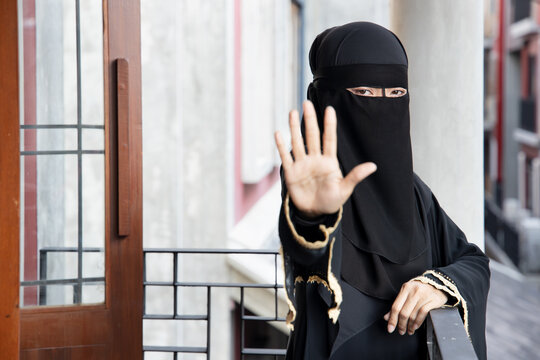 serious upset Middle Eastern muslim woman showing stop hand gesture