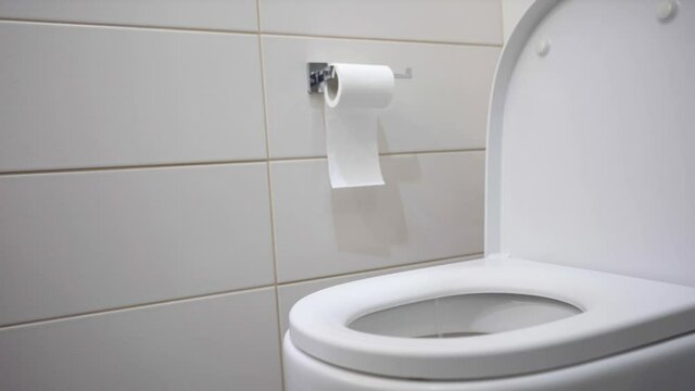 Black-haired brunette teenager vomiting in white bathroom