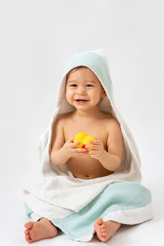 Cute baby wrapped into hooded towel after a bathing
