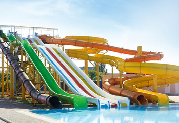 Different colorful slides in water park on sunny day