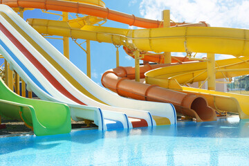 Different colorful slides in water park on sunny day