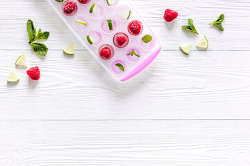 Naklejka na ściany i meble Ice tray with berries, lime and mint on white background top view copy space
