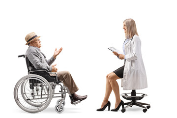 Young female doctor sitting on a chair and talking to an elderly male patient in a wheelchair