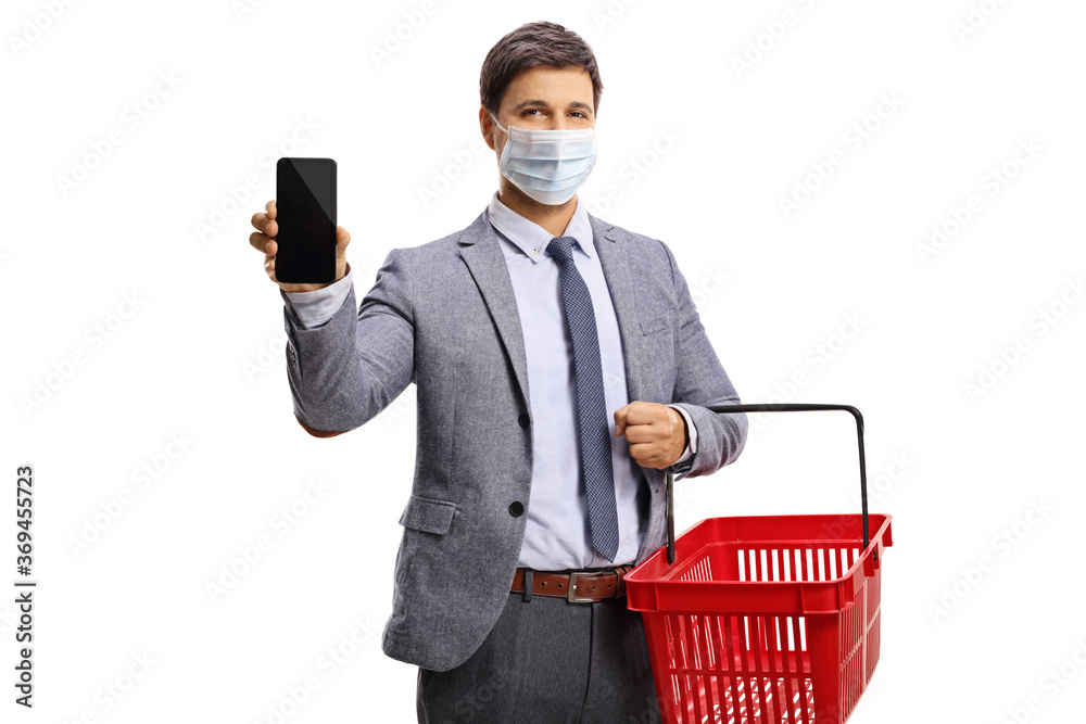 Wall mural Man with a shopping basket showing a smartphone and wearing a protective face