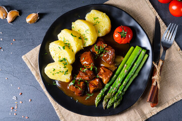 dumplings with beef goulash and green asparagus
