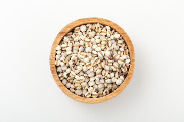 Pearl barley in wooden bowl on white background