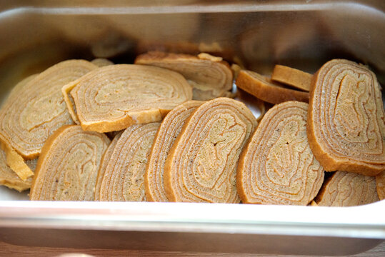 Pieces of sliced tomago amlet in a container, close-up.