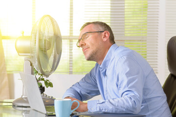 Man suffers from heat in the office or at home
