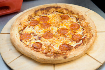 Pipperoni pizza on a cutting board.