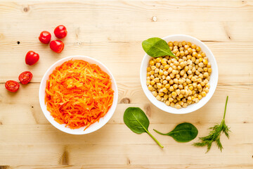 Vegetarian bowl with chickpeas and vegetables - wooden table top view