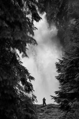 silhouette of a man standing on a rock under the waterfall in Krimml in Austrian Alps