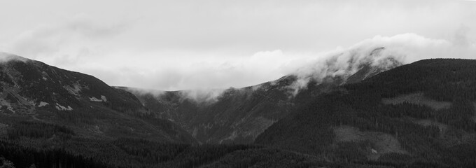 Obraz premium Panoramatic shot of the Sněžka mountain in the clouds on a cloudy day
