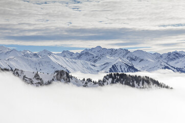 Snow covered mountains with inversion valley fog and trees shrouded in mist. Scenic snowy winter...