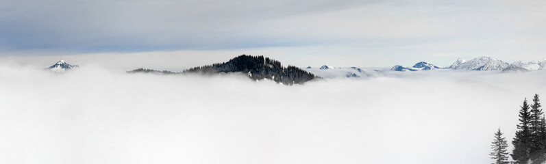 Winter Panoramic View to snow covered mountains above the clouds of inversion fog. View from...