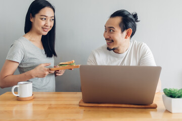 Asian wife is taking care of her husband in concept work from home.