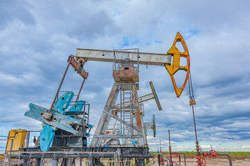 Petroleum concept. Oil pump rig. Oil and gas production. Oilfield site. Pump Jack are running. Drilling derricks for fossil fuels output and crude oil production. Global crisis. War on oil prices.