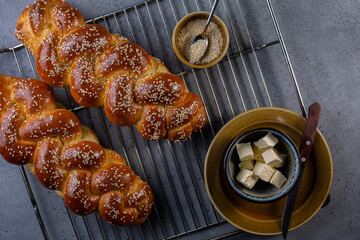 Homemade bread - Challah, Jewish cuisine and butter. Made from eggs, white flour, water, yeast, sugar. Decorates with sesame and poppy seeds.