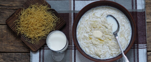 Sweet boiled vermicelli with milk in a ceramic bowl.