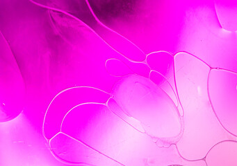 Abstract background create pink and purple art pattern generated by swirling brightly coloured paints through a milk base.